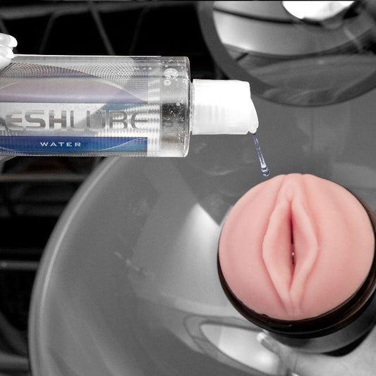 Aplicación de lubricante a base de agua Fleshlight sobre la abertura vaginal realista del masturbador masculino Pink Lady en silicona rosa